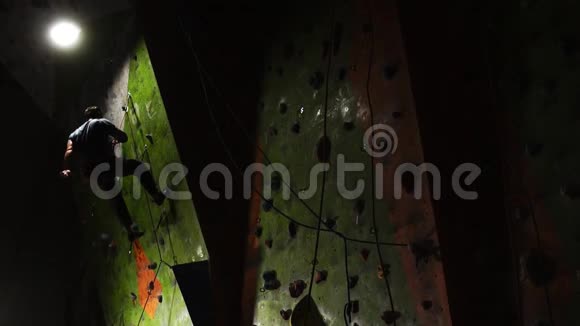 在攀岩比赛中职业攀岩者用最后胜利的安全绳攀岩下降到视频的预览图