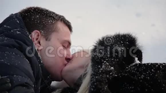 美丽的年轻夫妇牵着手在雪地上玩得很开心城市冬季公园视频的预览图