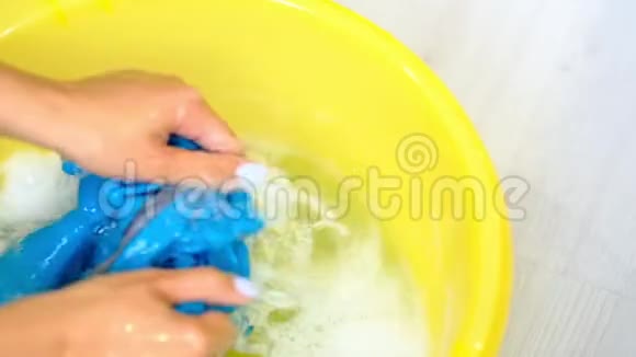 慢动作亚洲女性洗手盆用洗涤剂用手清洗脏衣服的污渍视频的预览图
