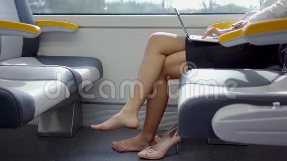 赤脚女人在火车上用笔记本电脑视频的预览图
