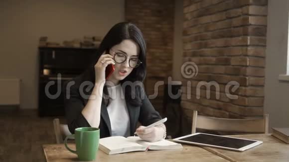 戴眼镜的年轻时尚女性通过电话交谈视频的预览图