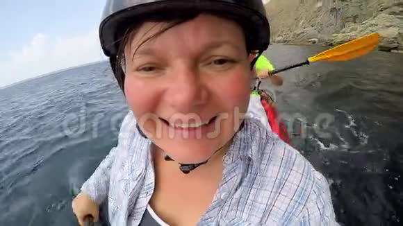 一个女人坐着皮划艇游进大海对着镜头视频的预览图