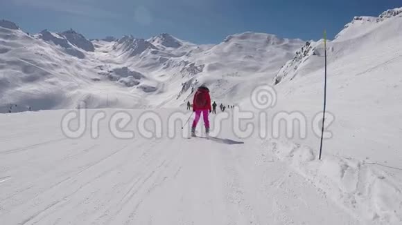 运动后景滑雪者滑下山地滑雪坡视频的预览图