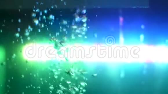 背景上有绿色灯的鼓泡水侧面视图框架空气气泡在水下的空鱼水族馆视频的预览图