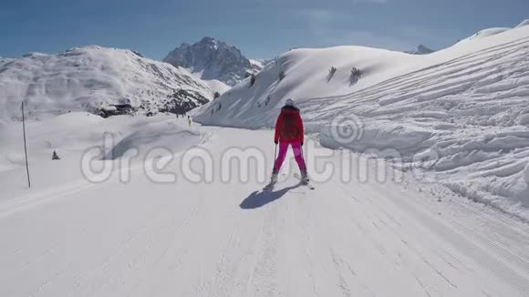 滑雪者在山上滑雪场滑下滑雪坡后景视频的预览图