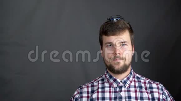 一名穿格子衬衫的男子从头上发射了一架迷你无人机视频的预览图