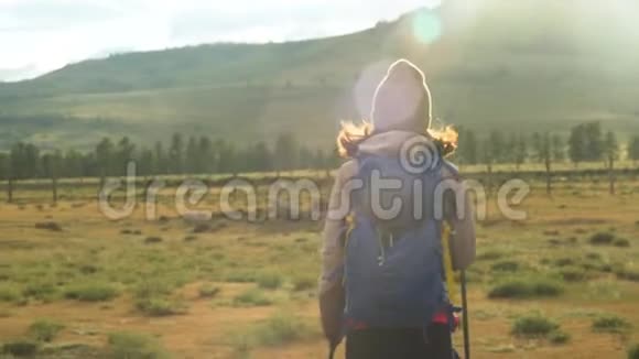 女人徒步旅行在山上远足带背包的女旅行者在美丽的夏季景观上晴天视频的预览图