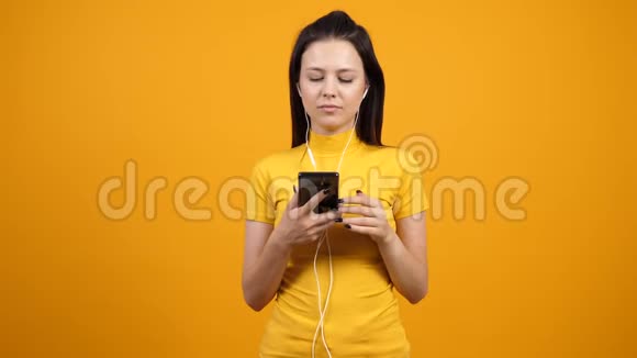 快乐的女人在智能手机上一边听音乐一边跳舞和唱歌视频的预览图
