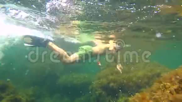水下潜水员在岩石周围游泳视频的预览图
