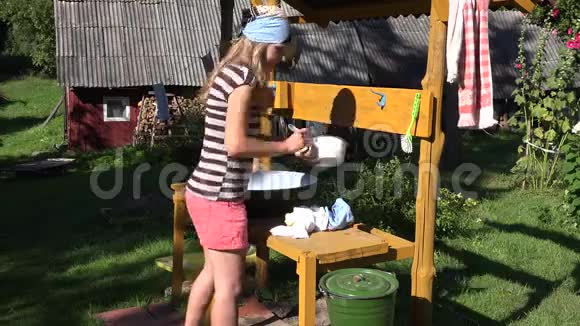 美丽的村民妇女在农场院子里用金属碗洗手4K视频的预览图