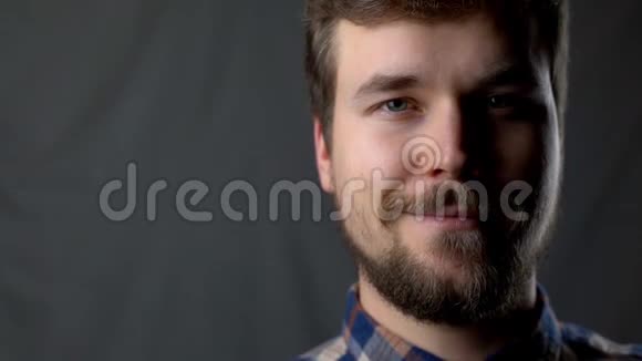 一个男人穿着格子衬衫在工作室里微笑视频的预览图
