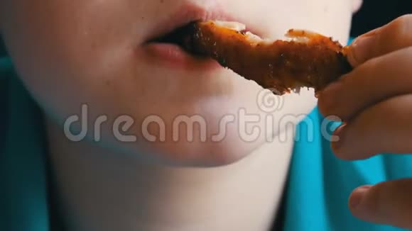 青少年嘴巴的特写镜头有食欲的男孩在快餐店吃炸鸡翅视频的预览图