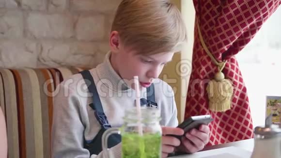 坐在咖啡馆里拿着智能手机的青少年商务午餐视频的预览图