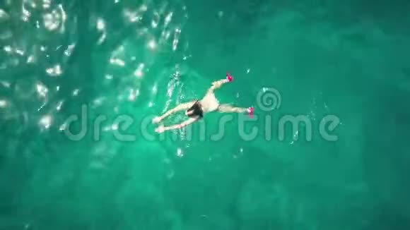 一位年轻女子在海中游泳的空中上上下下的上升镜头视频的预览图