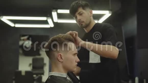 理发师在理发店理发后用喷发剂做发型年轻英俊的白种人视频的预览图