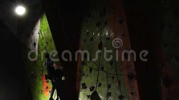 在训练和准备攀岩比赛期间一名专业攀岩者被举在安全绳上男性视频的预览图