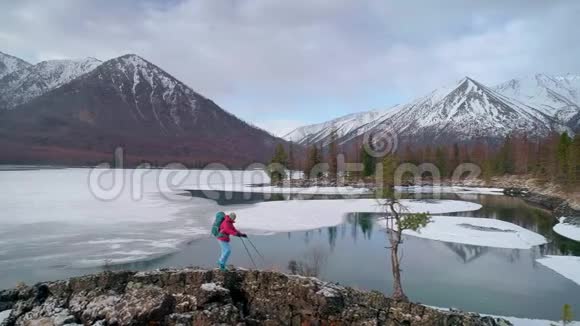 冬天徒步旅行者沿着山谷的海岸线前进空中飞行视频的预览图