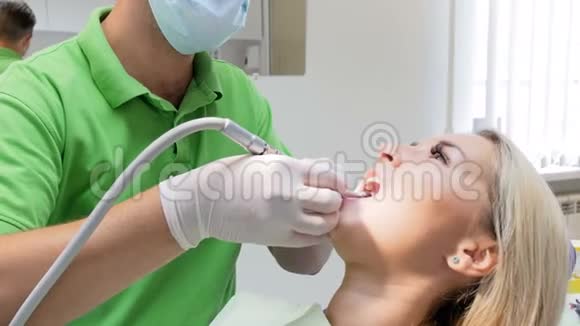 牙科医生在治疗病人的牙齿时用钻头拍摄4k镜头视频的预览图