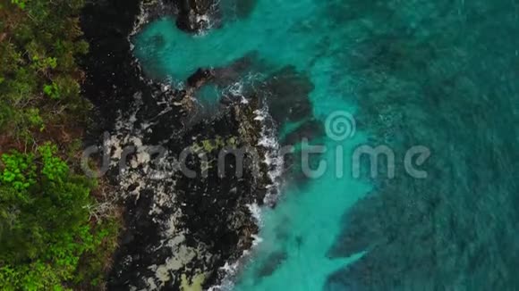 热带蓝色海洋和黑色岩石的鸟瞰图视频的预览图