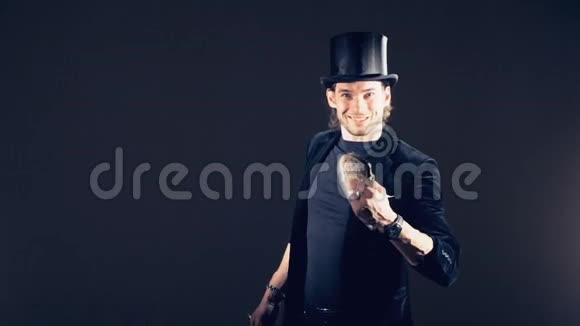 一个男性魔术师正在用卡片表演魔术把它们组合成卡片顶帽子视频的预览图