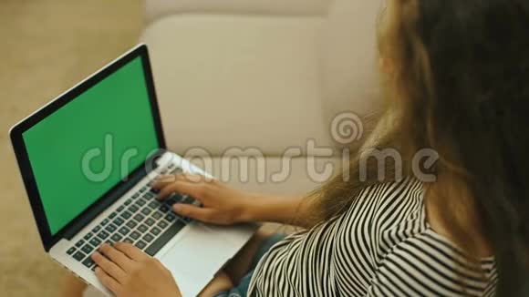 沙发上的少女正在用笔记本电脑在网上搜索带着笔记本电脑的少女正对着镜头微笑视频的预览图