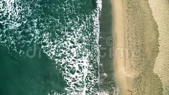 从空中俯视海滩上有许多脚印的海浪视频的预览图