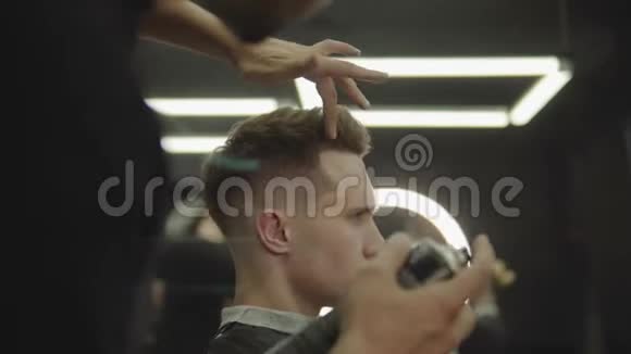 理发师在理发店理发后用喷发剂做发型年轻英俊的白种人视频的预览图