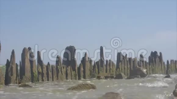 波浪被打破围绕着一系列古老的木柱从水中侵蚀视频的预览图