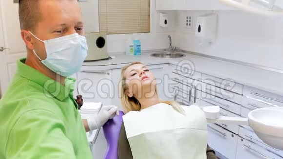牙科医生检查病人牙齿时调节灯4k镜头视频的预览图