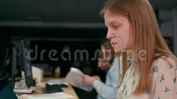 4年轻女子正在办公室的电脑旁工作视频的预览图