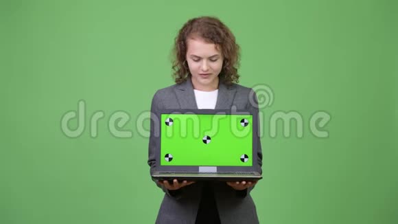 年轻漂亮的女商人展示笔记本电脑低头看视频的预览图