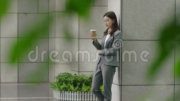 一位年轻的亚洲公司高管正在喝杯咖啡视频的预览图