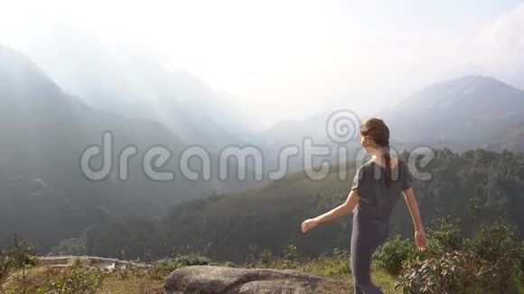 徒步旅行的概念越南日出时站在山崖上的女人举手视频的预览图