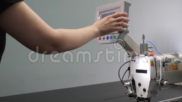 一名工人正在用平板电脑编程一台数控缝纫机操作人员设置数控机床视频的预览图