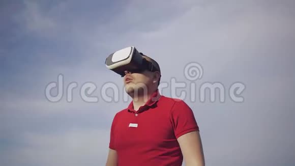 一个年轻人用虚拟现实眼镜对着天空视频的预览图