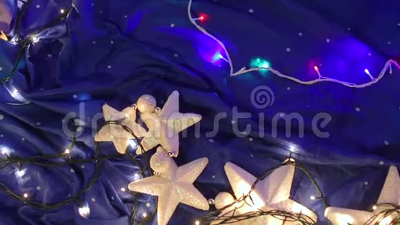 白色的星星花环躺在蓝色的背景上视频的预览图