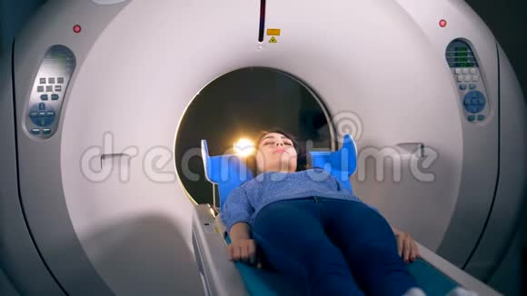 一个年轻的女人在做CT扫描前面朝上躺着视频的预览图