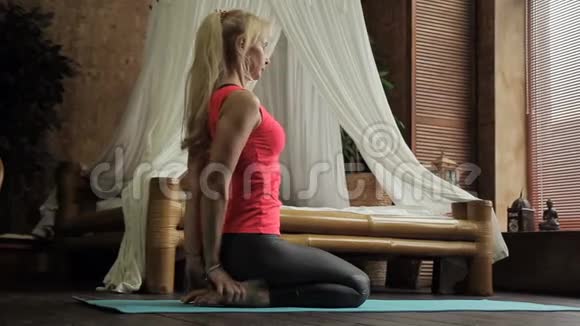 金发女人早上在她的卧室里进行瑜伽训练视频的预览图