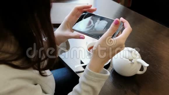 不可辨认的黑发女人长发照片一杯茶和茶壶在桌子上上景视频的预览图