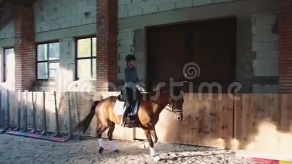 女子训练和骑马在沙地竞技场屋顶视频的预览图