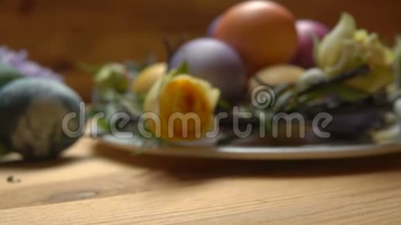 一朵黄色的玫瑰花瓣落在一张带有复活节彩蛋的桌子上视频的预览图