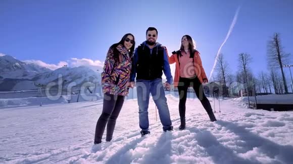 一群朋友在冬天的山上度假玩得很开心一个男人和两个女孩在滑雪场享受冬天视频的预览图