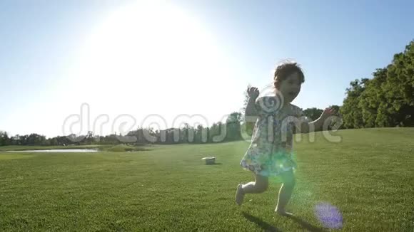 在公园草地上奔跑的小女孩视频的预览图