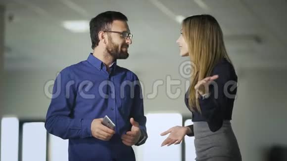 两位同事在休息咖啡时在办公室聊天穿蓝色衬衫的男人和女人交流视频的预览图
