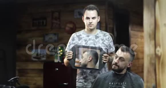 理发师正在用镜子向客户展示新发型视频的预览图