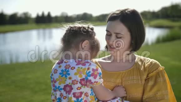 公园里的快乐妈妈和女儿在镜头前摆姿势视频的预览图
