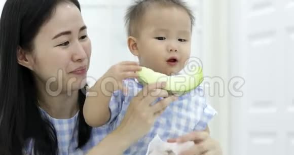 小亚洲男孩和妈妈一起吃瓜果照顾视频的预览图