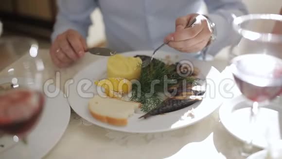 在餐馆吃饭的人在餐馆吃饭海鲜吃烤鲭鱼的人用盘子里的土豆视频的预览图