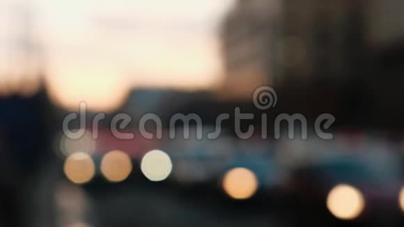 在交通堵塞的情况下经过的模糊的汽车灯背景上的日落视频的预览图