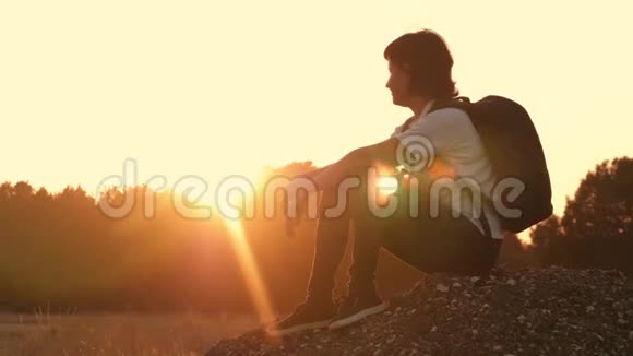 日落时坐在山上的女孩一个女孩在大自然中旅行健康生活方式的概念生活中视频的预览图